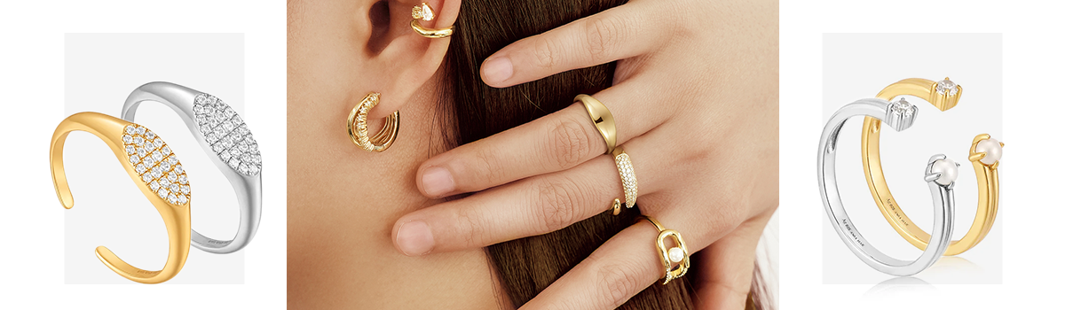 Stylish girl with her hand placed on neck showcasing a chic gold dome ring, a pearl sparkle interlock ring, and gold sparkle wrap adjustable ring. 