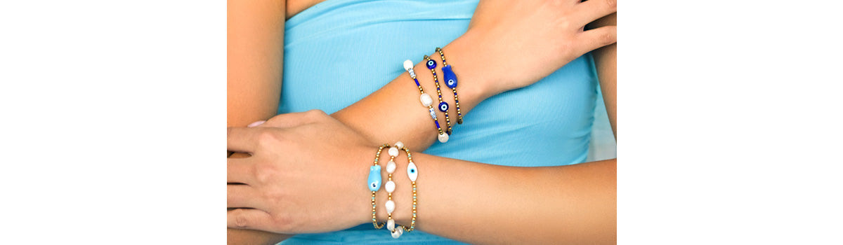 Stylish girls showcasing evil eye stackable bracelets with bright colored beads.