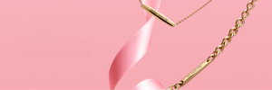 Engravable jewelry featuring gold bar necklaces and bracelets with personalized inscriptions, styled with a pink ribbon on a soft pink background.
