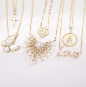 Madison L 14K gold diamond necklaces featuring pearl, butterfly, clover, cross, and letter “A” love pendants, crafted in luxurious yellow gold with sparkling details.