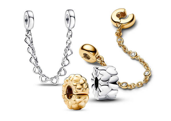 A collection of Pandora clips and safety chains including  14k gold-plated with three bezel-set stones safety chain, a sterling silver Heart Pattern Clip Charm, and linked hearts safety chain .