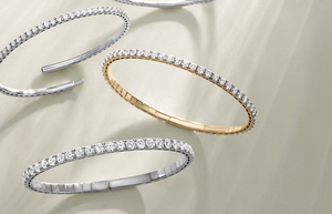 Flexible diamond bangles casting intricate shadows in sunlight, showcasing their brilliant sparkle and design.