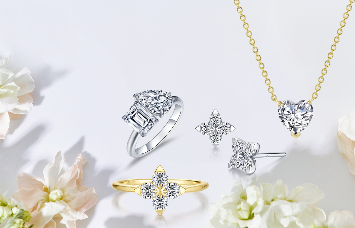 Sparkling Lassaire diamond rings, gold heart solitaire necklace, and sterling silver trillium bloom earrings displayed elegantly.