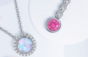 Lustrous opal and Lassaire simulated diamond necklace next to a vibrant pink birthstone charm pendant.