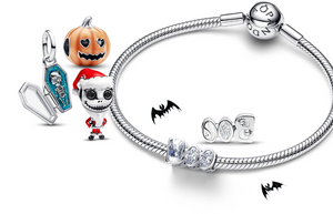 Pandora Halloween charms featuring sterling silver bracelet with sparkling “BOO” charm, Jack Skellington Santa charm, pumpkin charm, and skeleton-in-coffin dangle, accented with spooky bat graphics.