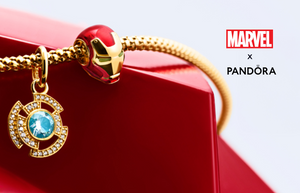 Marvel x Pandora gold bracelet featuring Iron Man helmet charm and blue arc reactor pendant accented with sparkling cubic zirconia.